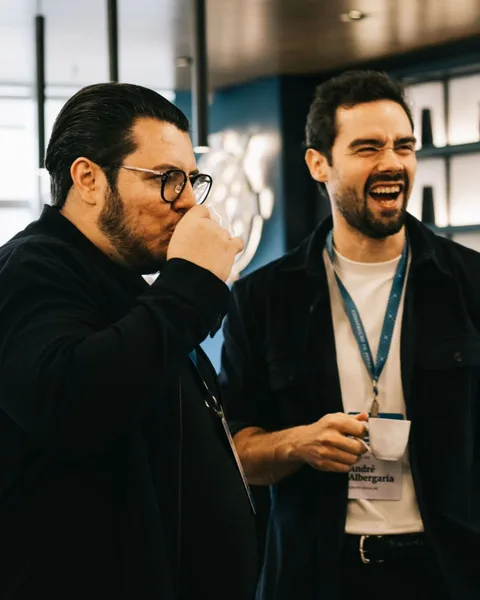 André, do Grupo Escalar, rindo ao lado de um cliente durante um evento