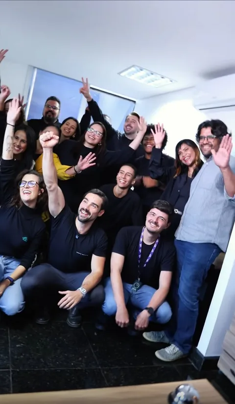 Equipe da Escalar comemorando reunida no escritório